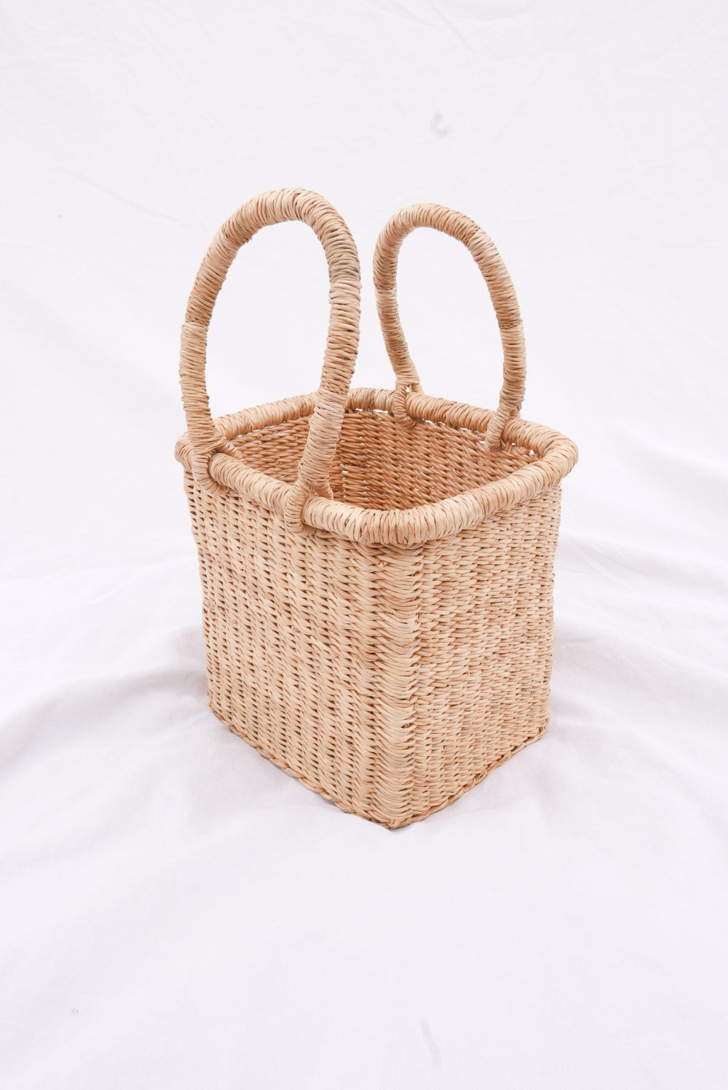 The Fuseini handbag is handwoven with straw called Kinkahe in Bolgatanga, Ghana. The shape is cube-like with two handles for durability. This product supports a community with employment, educational opportunities for the children and improve the work environment.